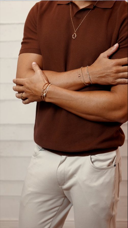 Polo marrom com colar, pulseiras e anel de ouro